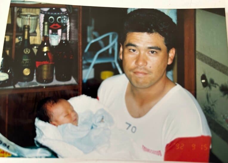 生後間もない福也を抱える章弘さん　写真は章弘さん提供
