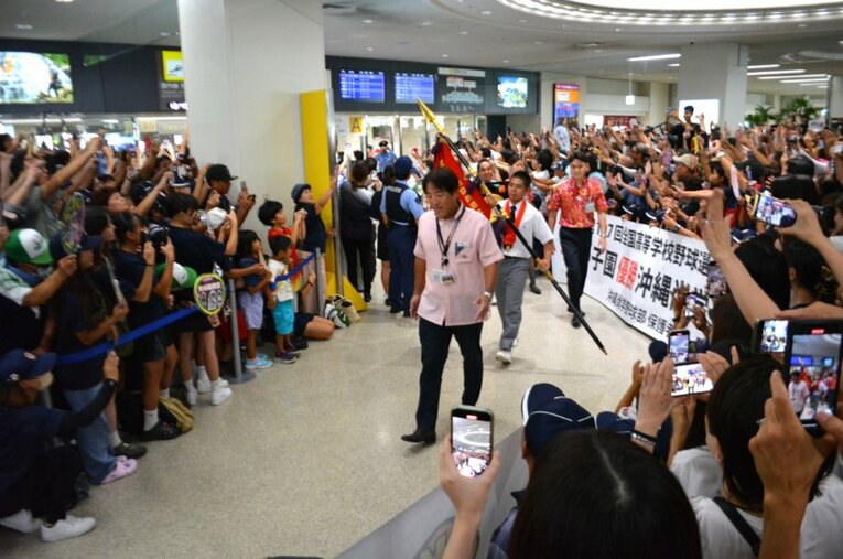 主将の真喜志拓斗を先頭に沖縄尚学の選手たちが姿を現した瞬間。那覇空港は大歓声に包まれた ／ photograph by Takarin Matsunaga