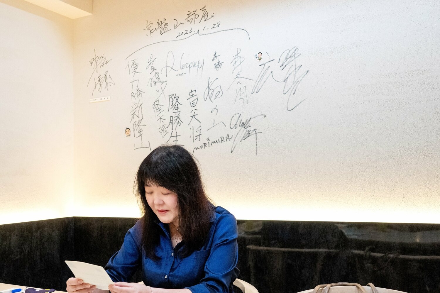 弟子たちからの手紙を朗読する常盤山部屋のおかみ、ルミコさん。部屋のみんなの行きつけ「鮨サロン 怜竜」にて ©Takashi Shimizu