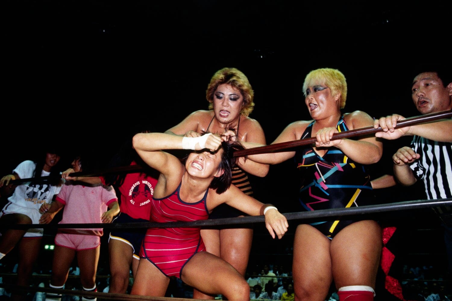 1985年、極悪同盟のダンプ松本、クレーン・ユウの凶器攻撃を受ける長与　©AFLO