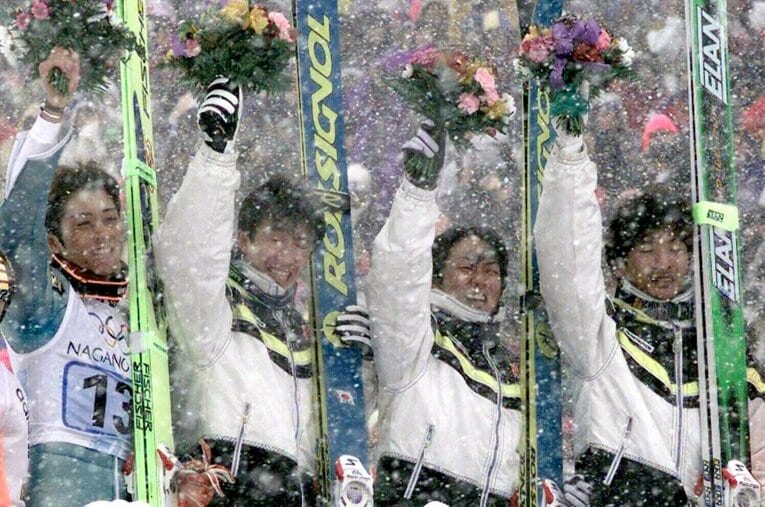 98年長野五輪、スキージャンプ団体優勝メンバー。フラワーセレモニーで観客に手を振る日本チーム。左から船木和喜、原田雅彦、岡部孝信、斎藤浩哉（長野県白馬村） ／ photograph by JIJI PRESS