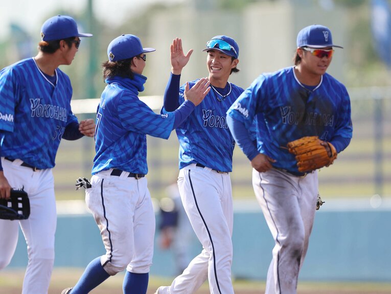 注目のドラ1・度会はニコニコ。対照的に泥だらけで練習に励むドラ4・石上　©JIJI PRESS