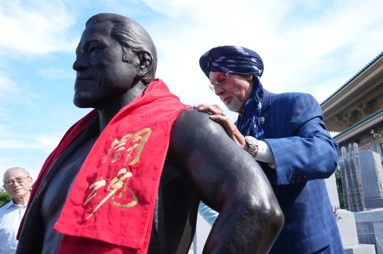 銅像の肩に闘魂タオルを掛けるタイガー・ジェット・シン。10月16日、横浜市鶴見区の總持寺　©Essei Hara