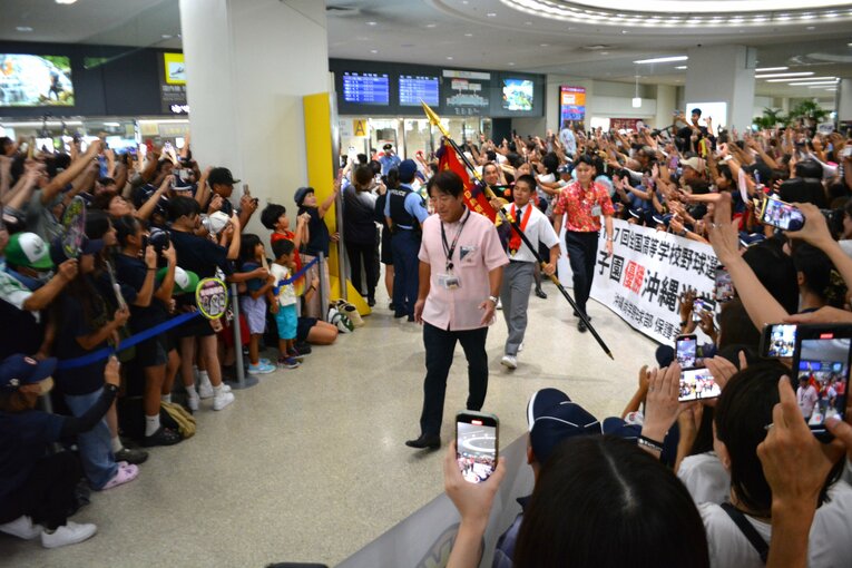 主将の真喜志拓斗を先頭に沖縄尚学の選手たちが姿を現した瞬間。那覇空港は大歓声に包まれた　©Takarin Matsunaga