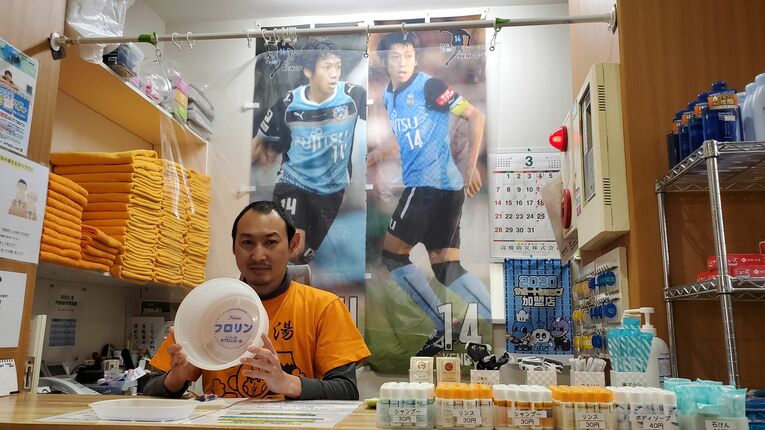 店主・松永さんが持つのは、2010年のキャンペーン景品となった懐かしの白い「フロリン」桶　©︎Takashi Kumazaki