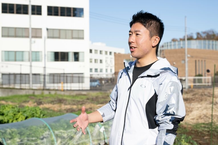 厚木キャンパス内の農地にて。加藤団長が今年のスペシャル大根について説明　©Nanae Suzuki