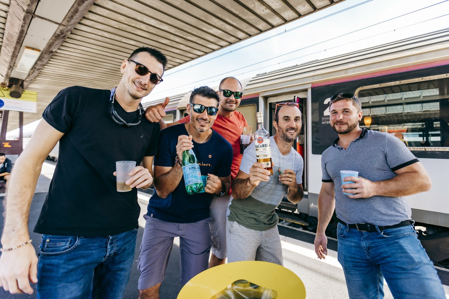 列車が2時間以上遅延するなか、ホームで陽気に飲んでいた集団。ラムを炭酸水で割っているようだ　©Kiichi Matsumoto