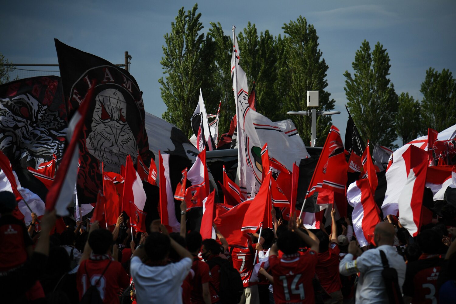 フラッグを振って選手バスを出迎えるサポーター