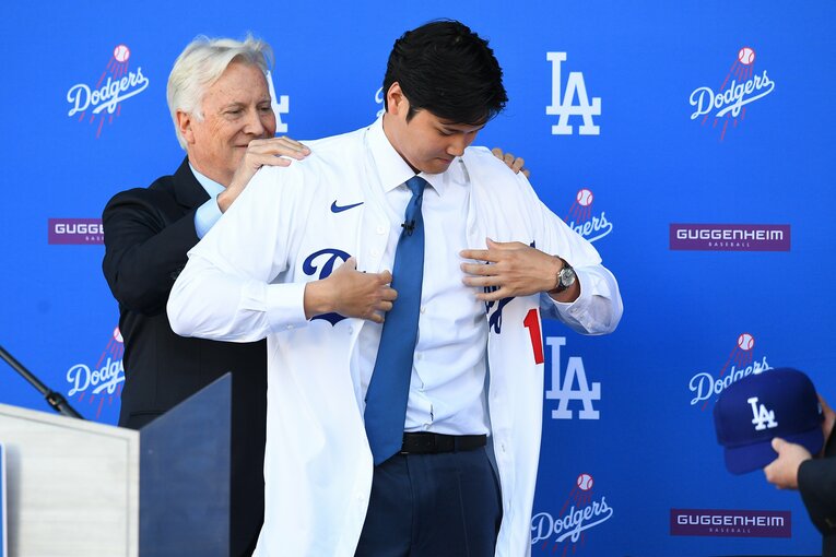 入団会見にてドジャースのユニフォームに袖を通した大谷　©Getty Images