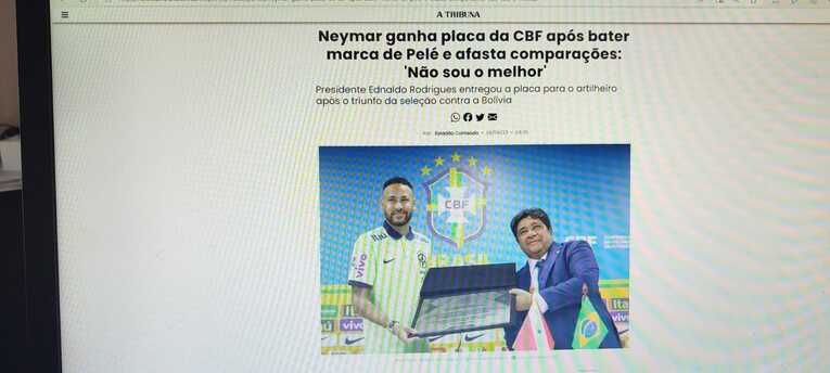 ブラジルサッカー連盟のロドリゲス会長から通算記録達成の記念プレートを受け取るネイマール（日刊紙「トリブーナ」電子版）