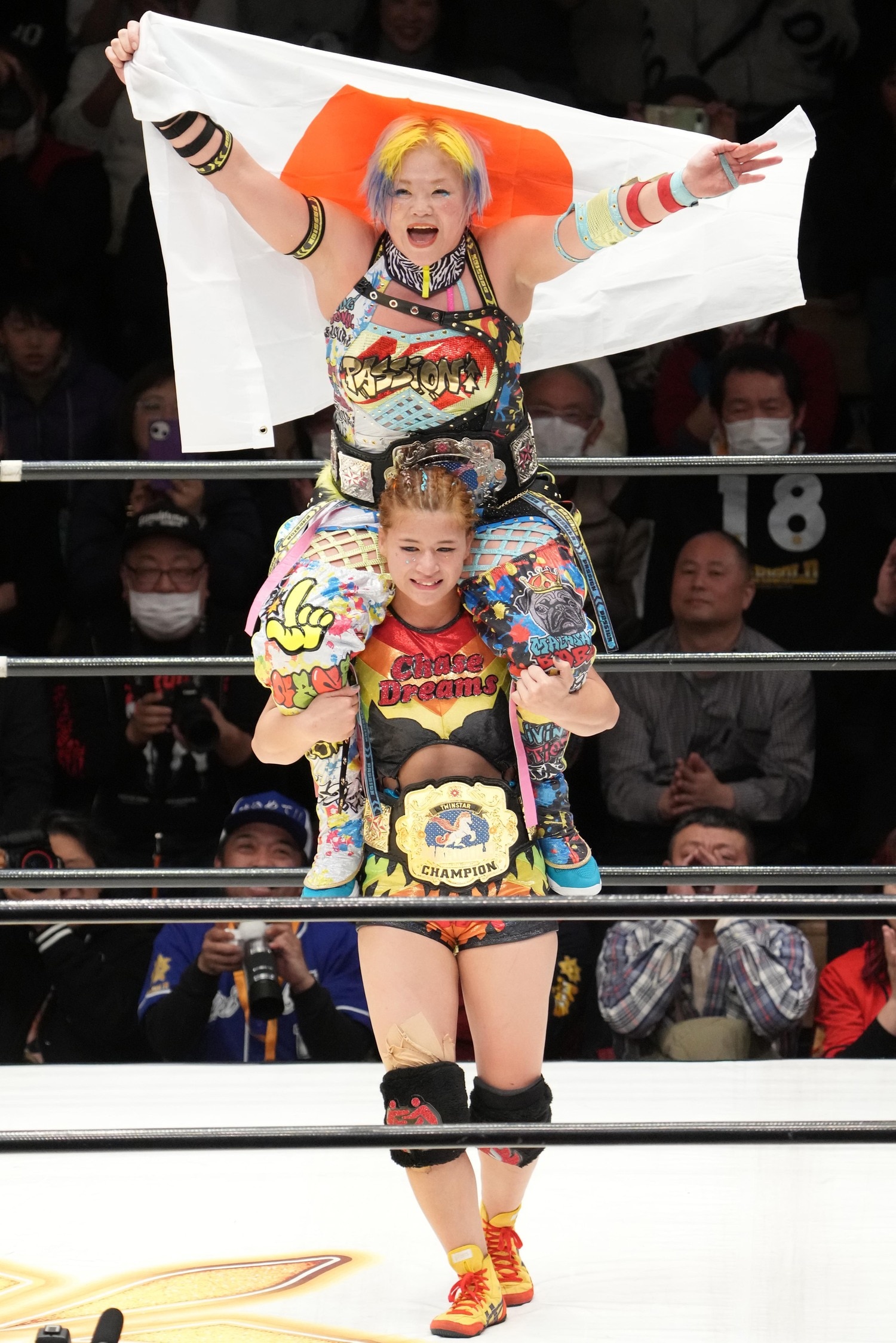 「これがやりたかった！」タッグ王者となり高橋奈七永を肩車して日の丸で祝う山岡聖怜　©Masashi Hara