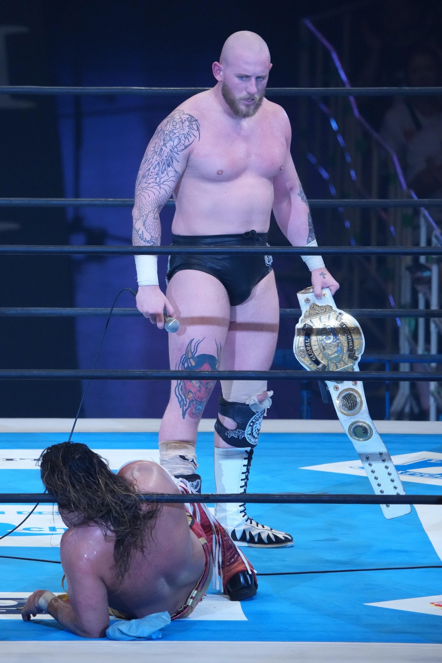 念願のIWGP GLOBAL王座のベルトを手にして辻陽太を見つめるゲイブ・キッド　©Essei Hara