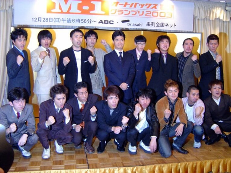 M-1グランプリ2003の決勝記者会見。（前列左から）2丁拳銃、麒麟、スピードワゴン、千鳥。（後列左から）アメリカザリガニ、フットボールアワー、大会委員長の島田紳助、りあるキッズ、笑い飯　©Sankei Shimbun