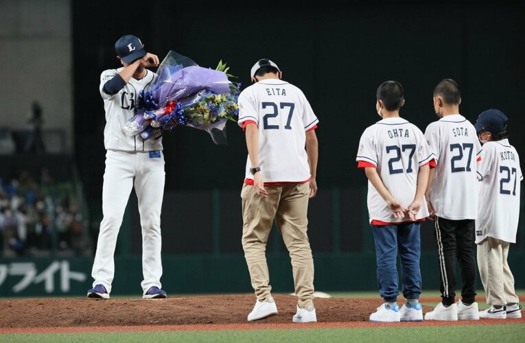 2022年9月20日。引退セレモニーで家族から花束を受け取り、涙をぬぐう内海哲也　©JIJI PRESS