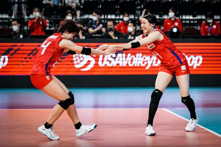 セッターの松井珠己（左）と笑顔でタッチをかわす石川真佑　©FIVB