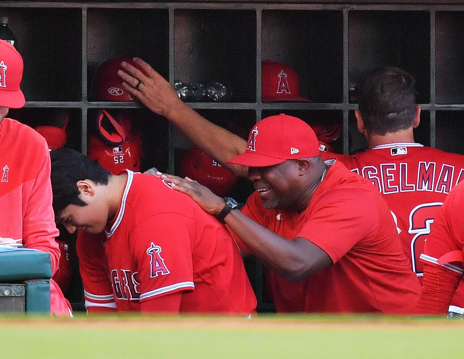 1回、ベンチでコーチに恒例の背中をたたいてもらう大谷　©JIJI PRESS