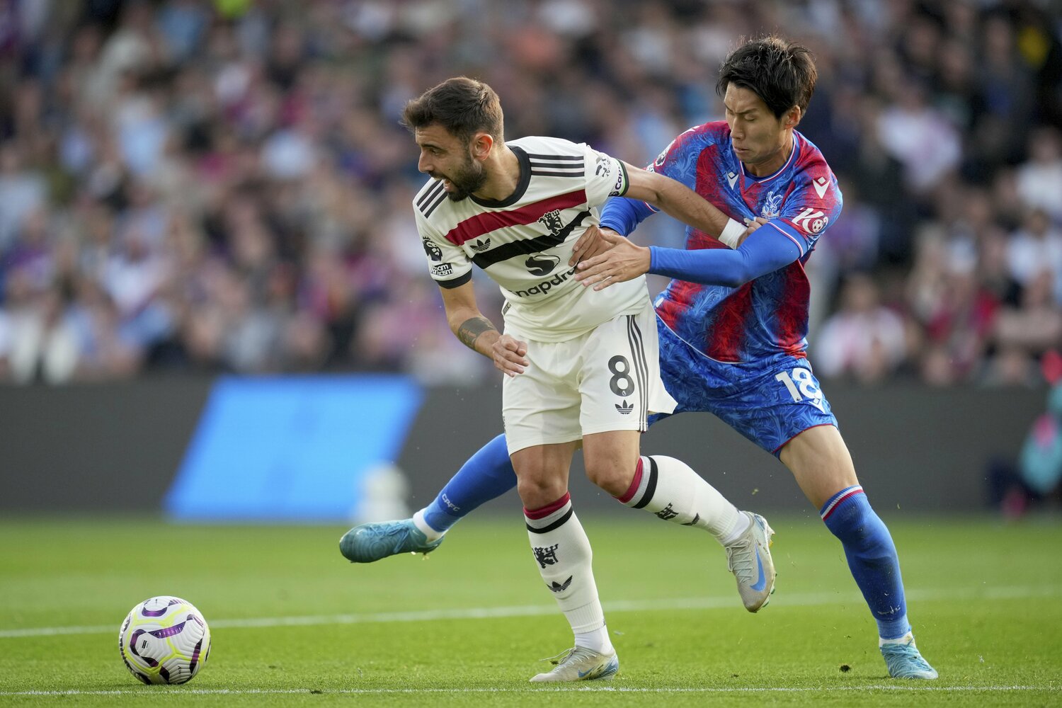 9月21日のマンチェスター戦、MFブルーノ・フェルナンデスと競り合う鎌田 ©AFLO