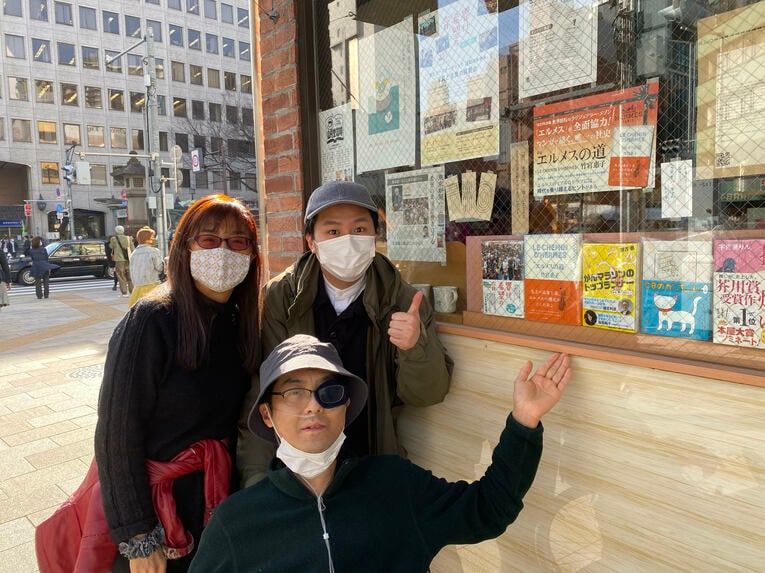昴さんは書店で自著を確認した。後方は母の美恵（よしえ）さんと末弟で移植ドナーの聖醐（しょうご）さん