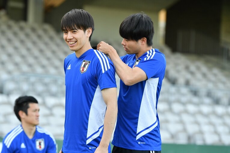 田中碧のユニフォームを治してあげる三笘薫【スワイプするとそのほかの写真もご覧になれます】　©JFA／AFLO