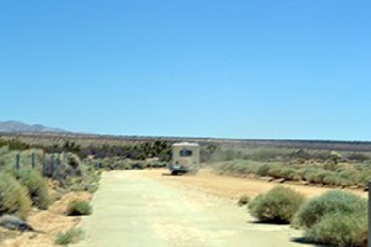 「Good Luck!」と砂埃を立てて去っていくジープ。 