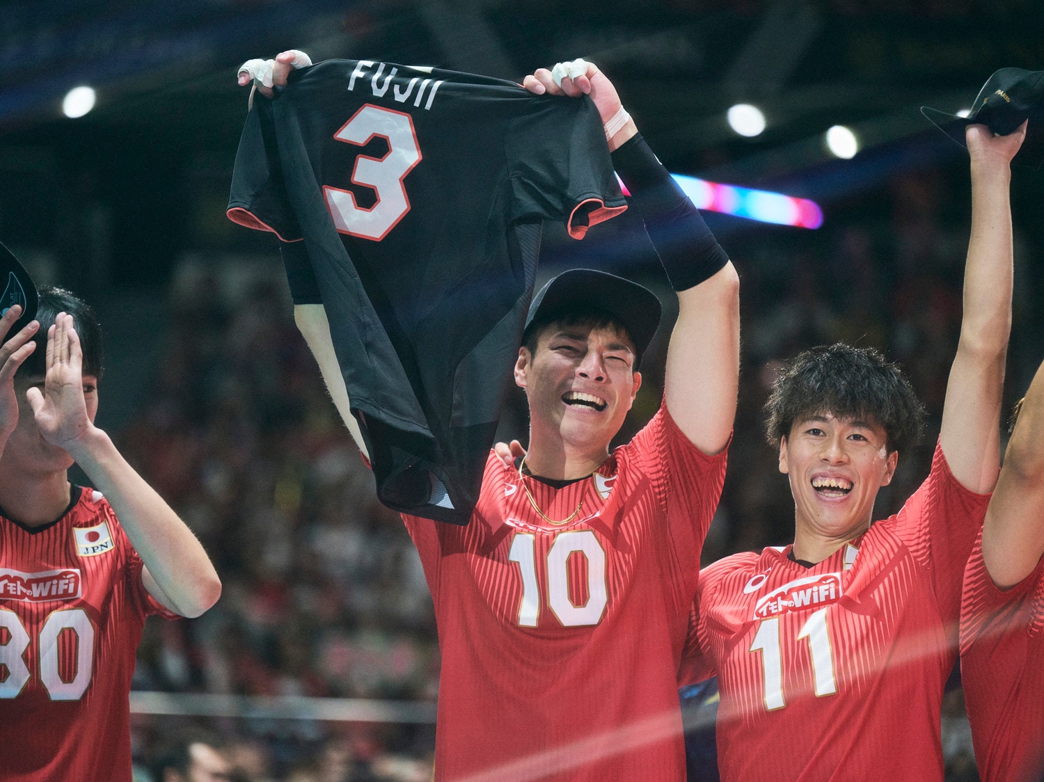 藤井直伸が日本代表で着用した「3番」のユニフォームを掲げる高橋健太郎（中央）と、コートに持ち込むことを提案した富田将馬　©︎Yuki Suenaga