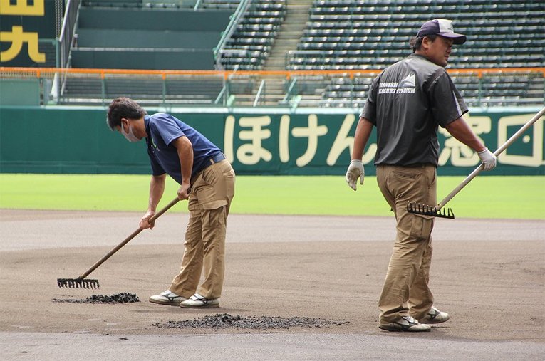 一塁ベース付近を整える金沢さんたち