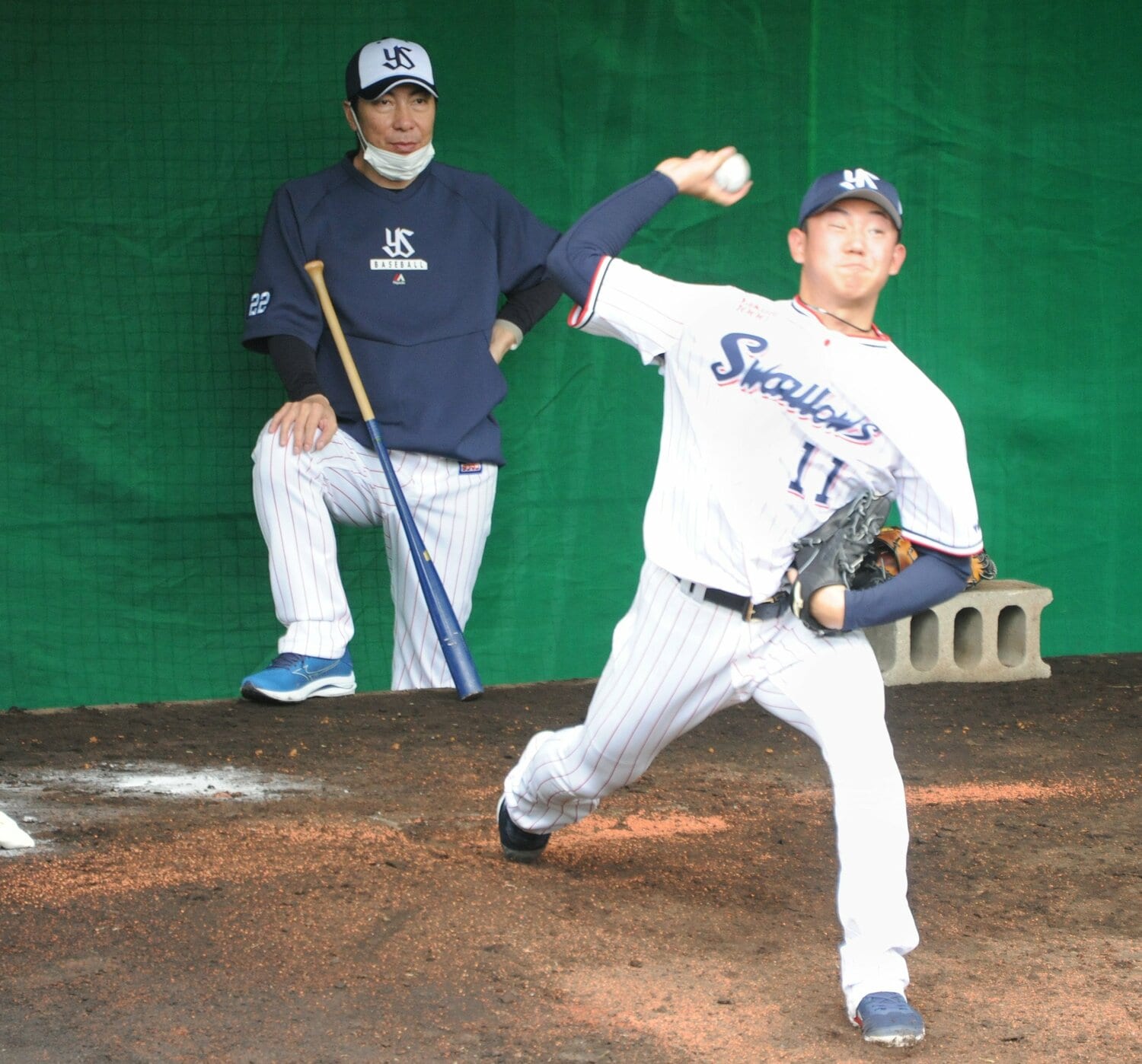 2023年2月のキャンプで奥川のブルペン投球を見つめる高津監督（左）　©︎JIJI PRESS