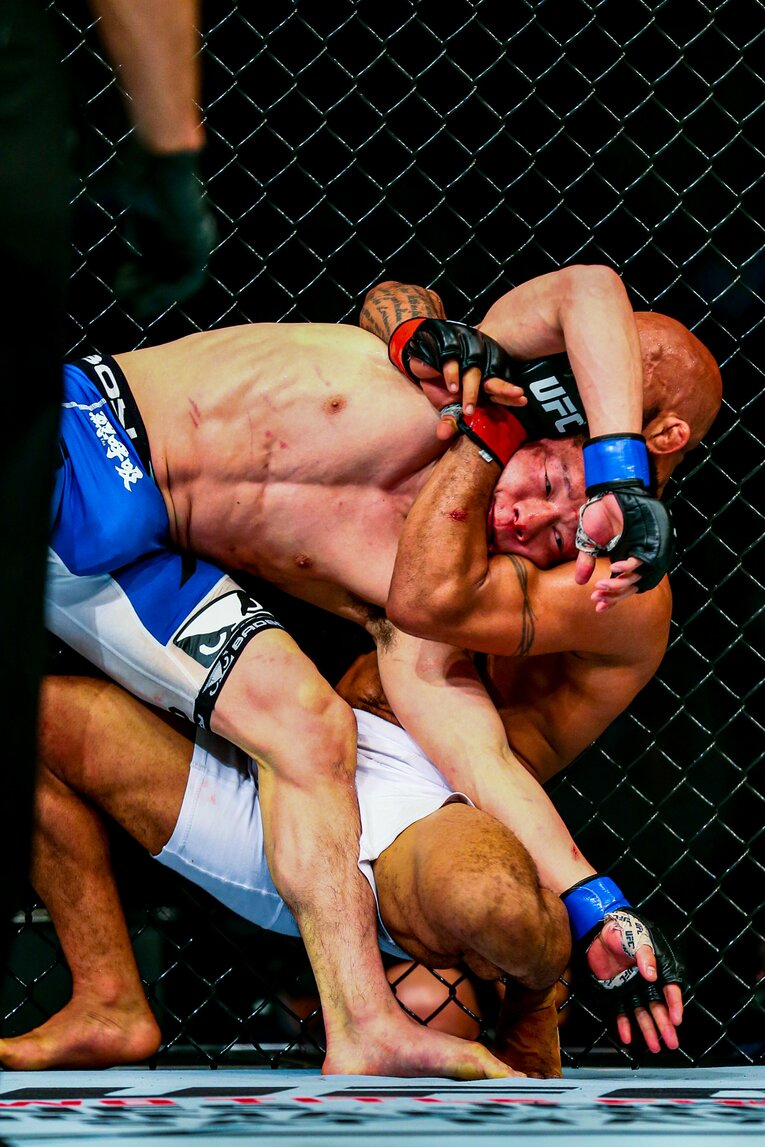 金網を背に堀口恭司を締め上げるデメトリアス・ジョンソン　©Susumu Nagao