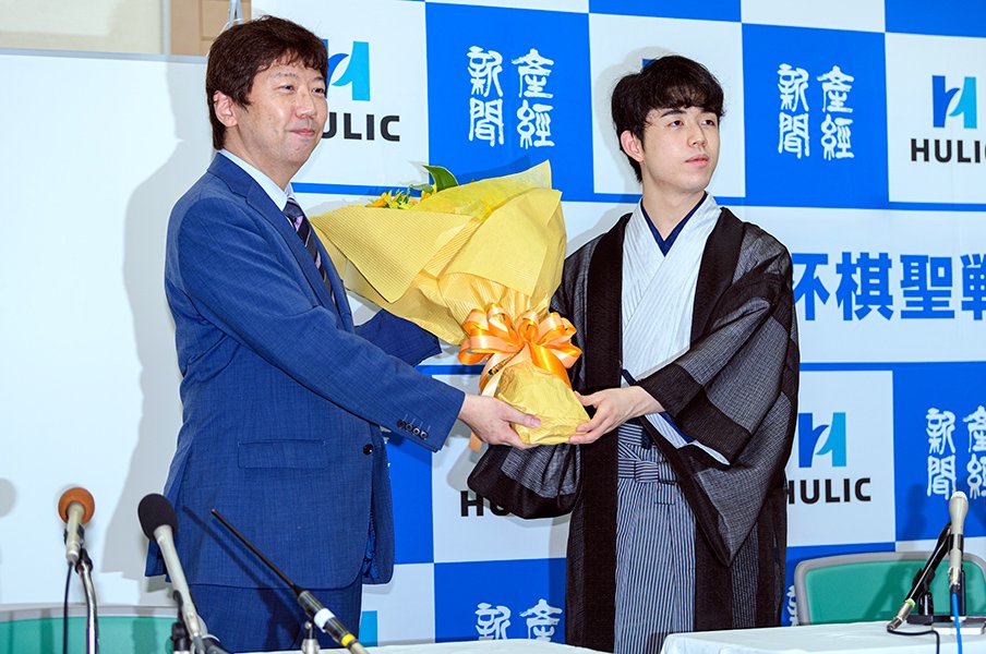 棋聖戦で史上最年少タイトル獲得を達成し、師匠の杉本昌隆八段から花束を贈られた©Takuya Sugiyama