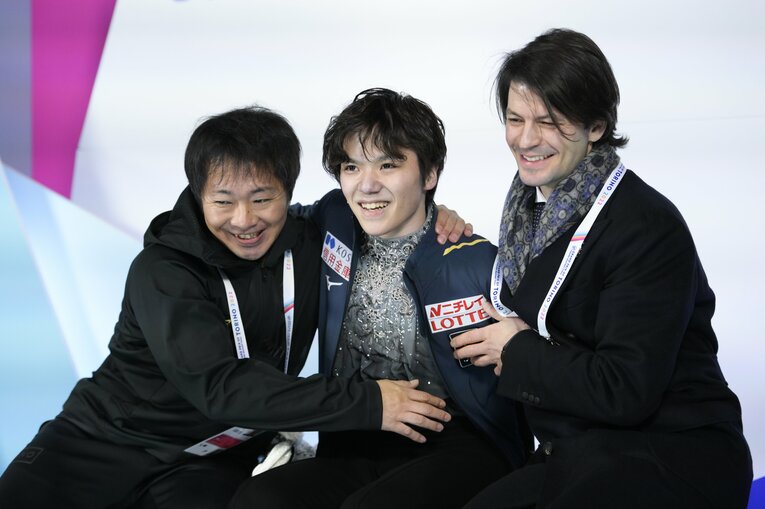 合計300点超えの瞬間、出水トレーナー（左）、ランビエルコーチ（右）と喜び合う宇野　©︎Asami Enomoto