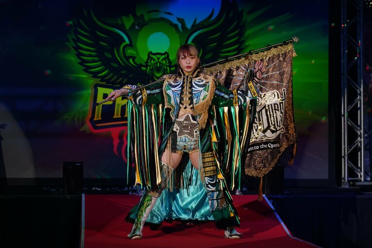 白いベルトを巻き、クイーンズ・クエストの旗を持った上谷沙弥の入場シーン