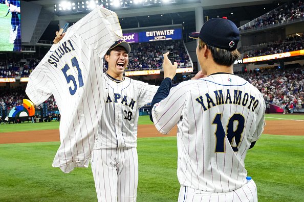 優勝が決まり敬愛する山本由伸と喜びを分かち合う高橋。手には故障で辞退した鈴木誠也のユニフォームが　©︎Getty Images