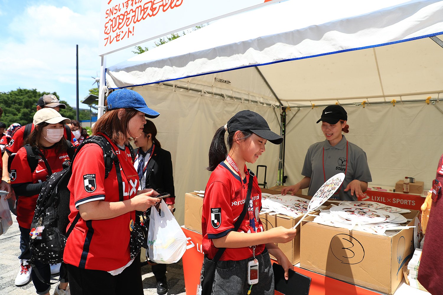 『アントラーズ推し活うちわ』の配布に並ぶアントラーズファン　©KASHIMA ANTLERS