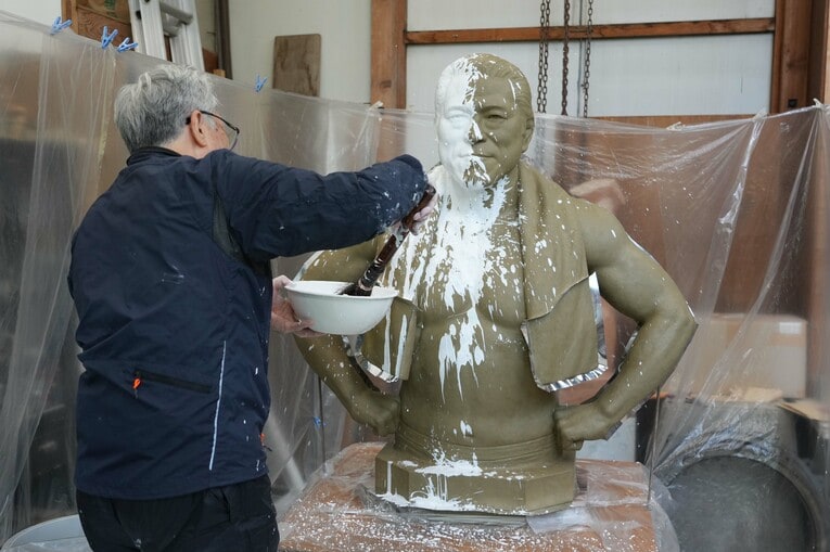 猪木像に石膏をかける井野雅文さん