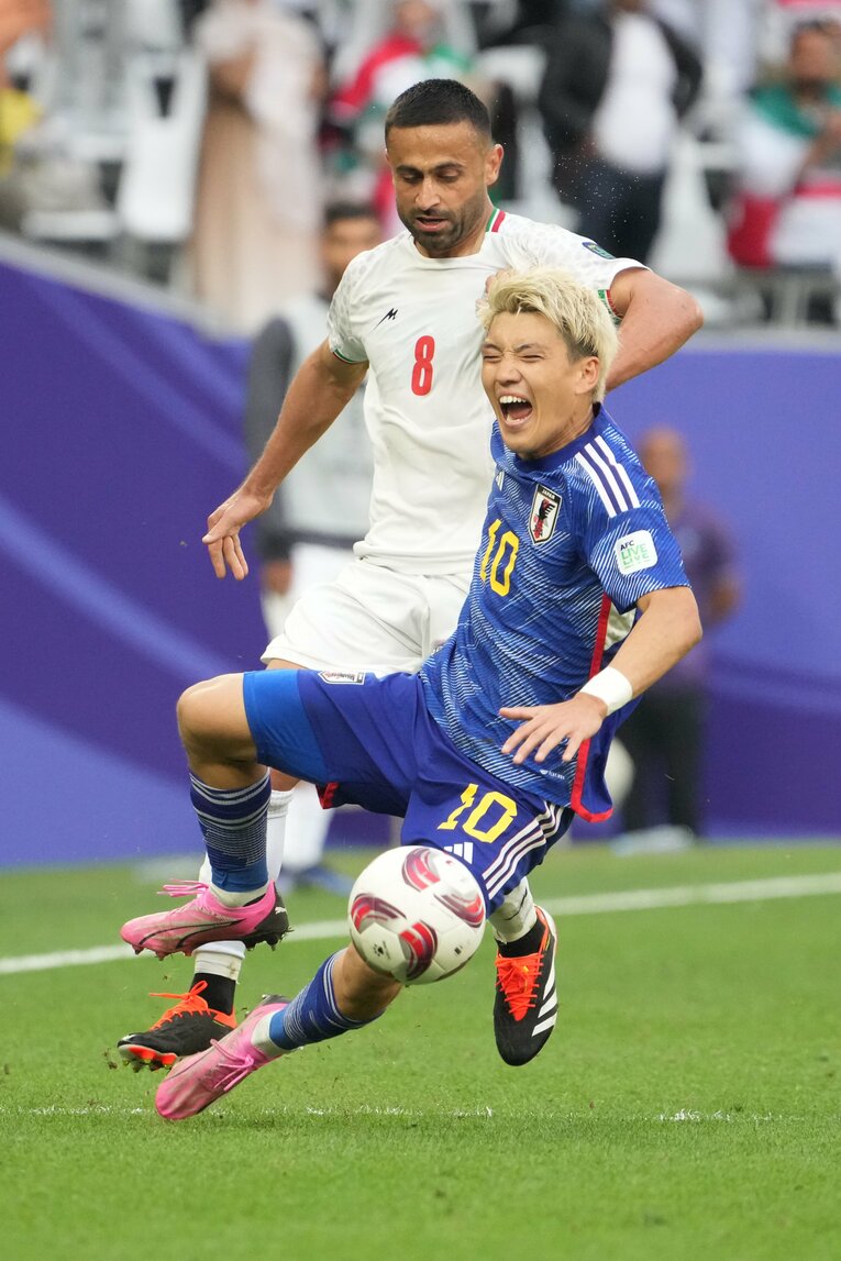 背後から倒される堂安律　©Masashi Hara