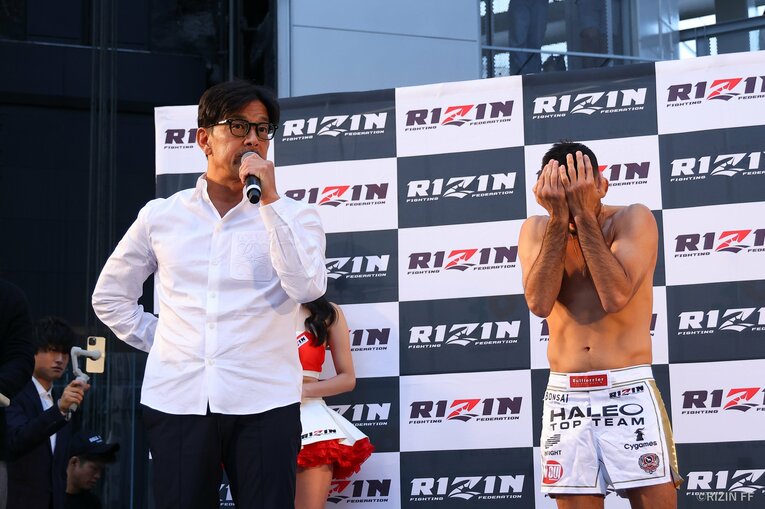 王座剥奪を告げる榊原信行CEOの隣で、クレベル・コイケは顔を覆った　©RIZIN FF