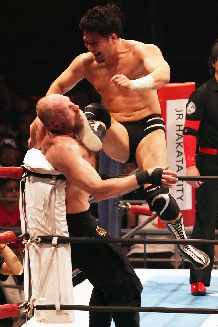 コーナーのジョン・モクスリーにジャンピングキックを放つ成田蓮　©Essei Hara