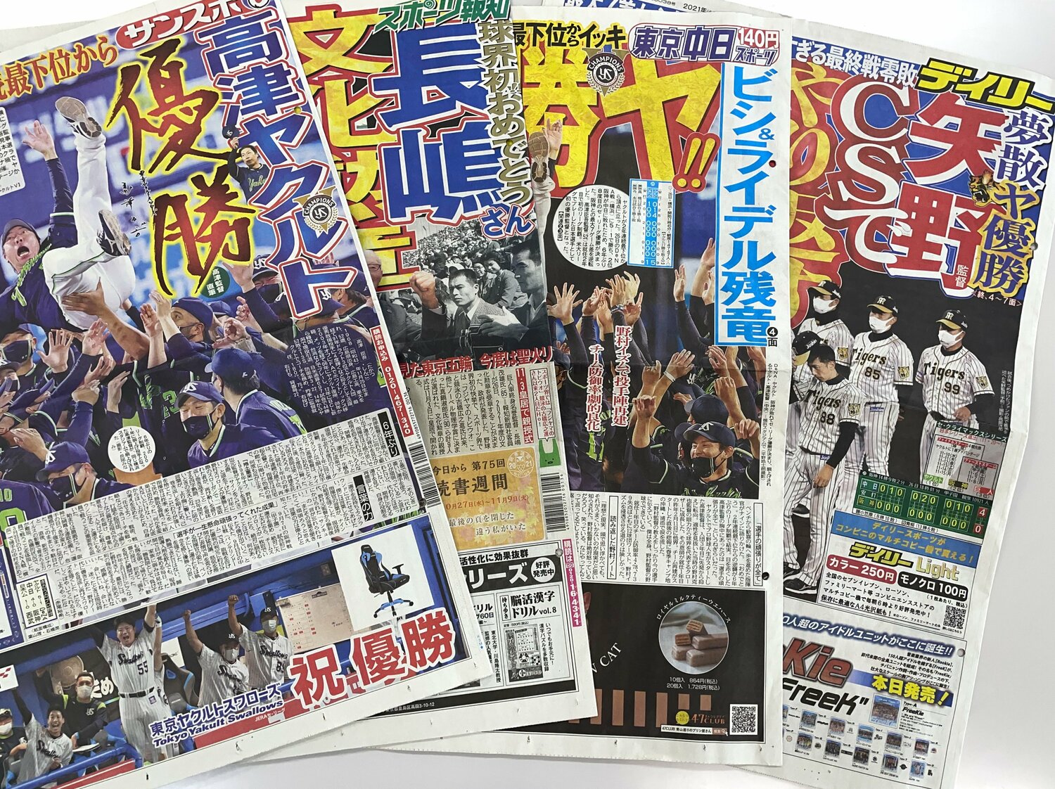 ヤクルトの優勝を報じる一面に各紙の特徴が色濃く現れる。特筆すべきは「サンスポ」で、3段広告までも優勝シーン！
