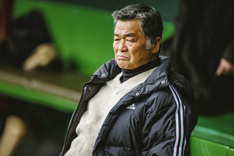 ベンチから試合前練習を見守る川藤氏　©︎Kiichi Matsumoto