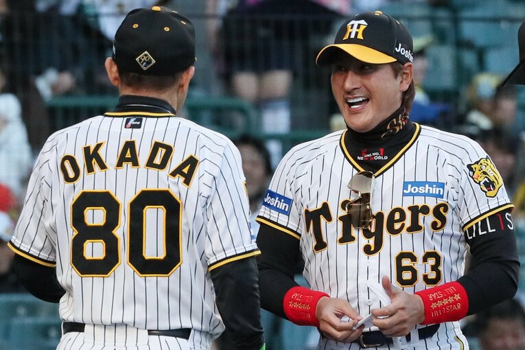 交流戦では阪神のユニフォーム姿で岡田監督とメンバー表を交換　©︎JIJI PRESS