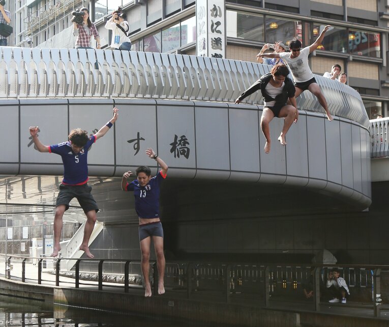 過去には何かと飛び込む人が続出していた道頓堀。写真は2014年ワールドカップで日本が1次リーグ敗退を受けてのダイブ　©JIJI PRESS