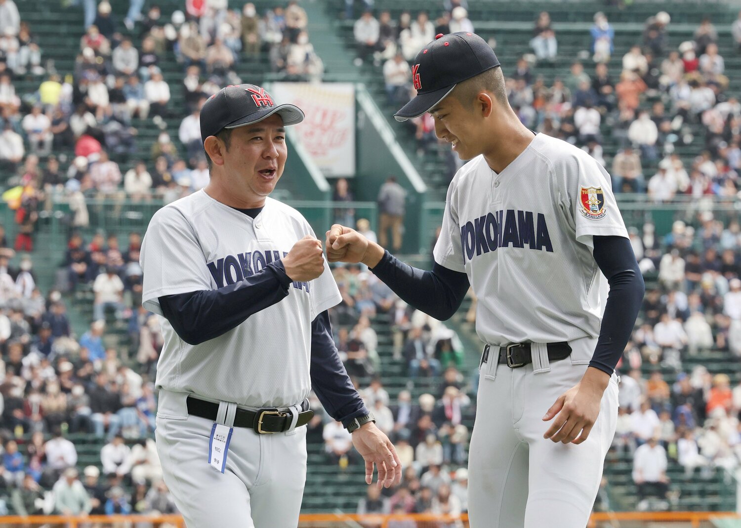 村田監督とグータッチする織田　©JIJI PRESS