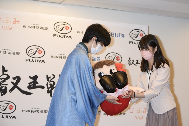 記念のマスコット「ペコちゃん」を贈られた藤井聡太新叡王　©Hirofumi Kamaya