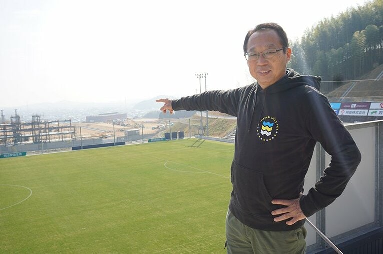 岡田武史会長が指し示す先に見える、建設中のFC今治新スタジアム。来年1月に完成予定だ ／ photograph by Toshio Ninomiya