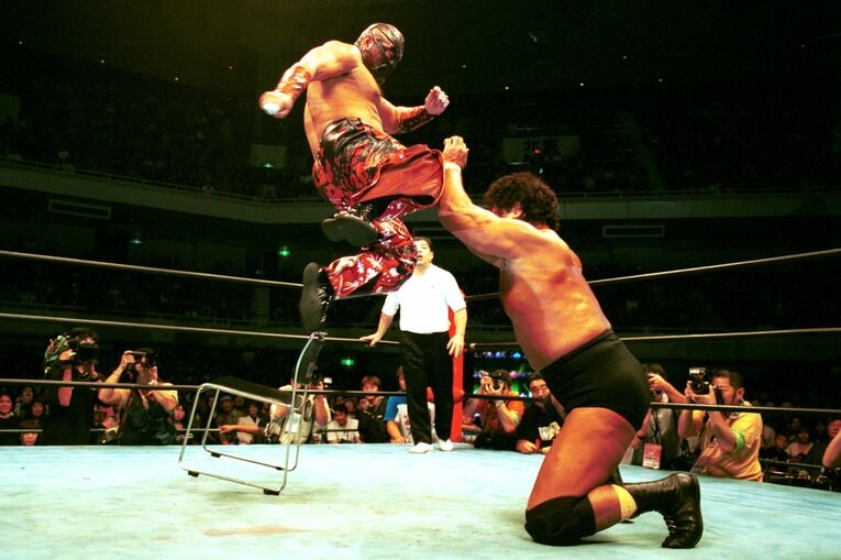 天龍にイスからのシャイニング・ウィザードを見舞うムタ。2002年10月27日、日本武道館