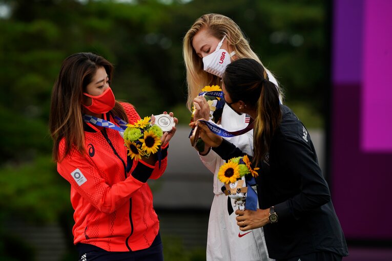 ともに表彰台に上がったネリー・コルダ（中央）、リディア・コ（右）とメダルを確かめ合う稲見萌寧　©︎Shizuka Minami