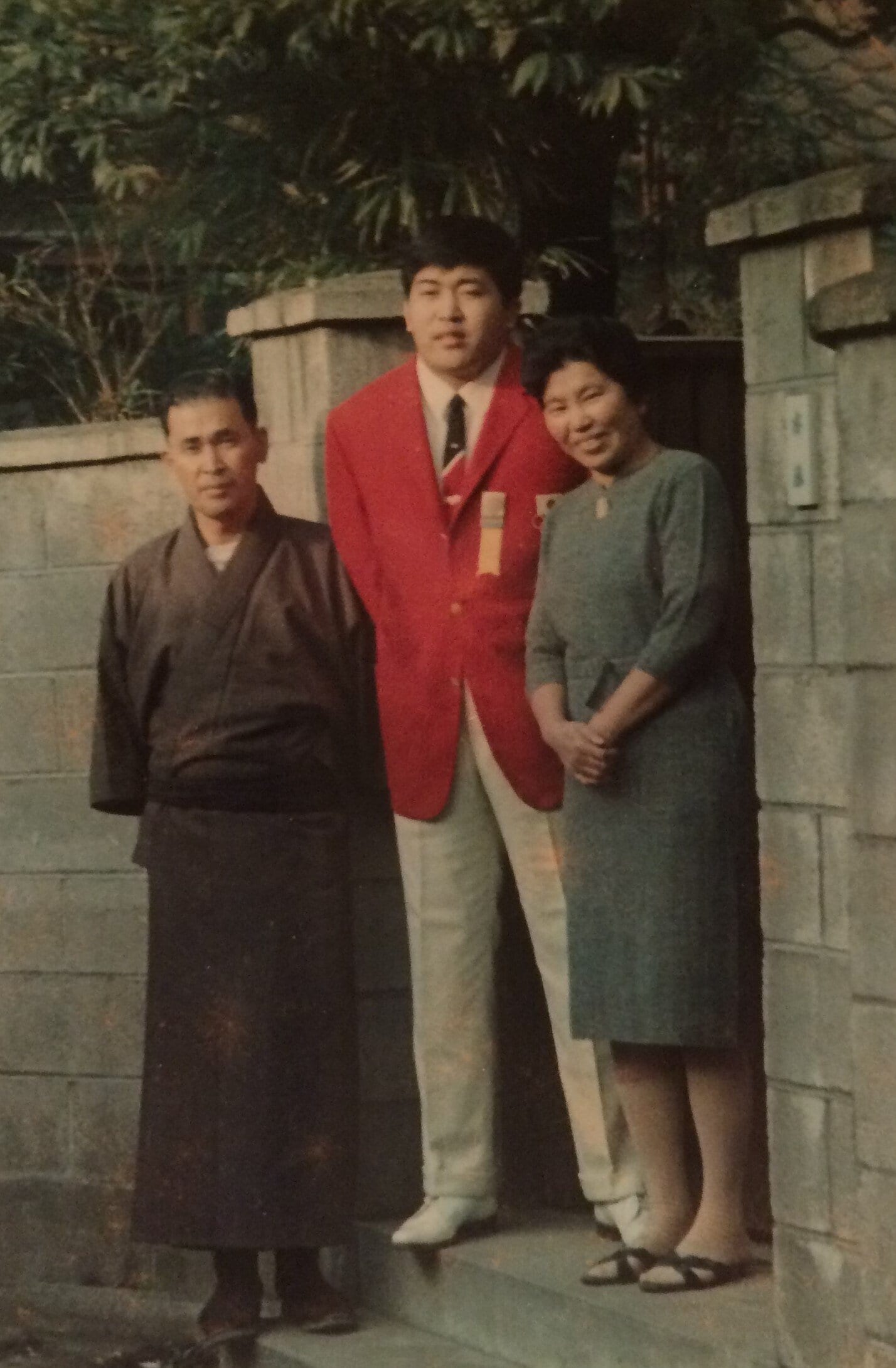 五輪ジャケットを纏い、両親と記念写真