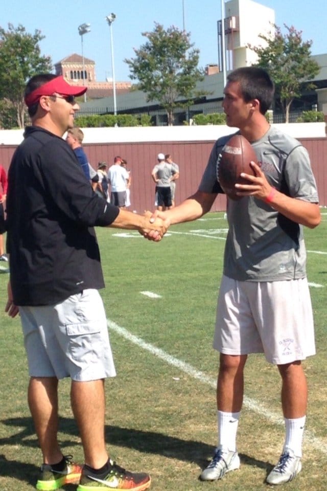 アメフト選手としてUSCのキャンプに参加し、当時のコーチと握手をするヌートバー（母・久美子さん提供）