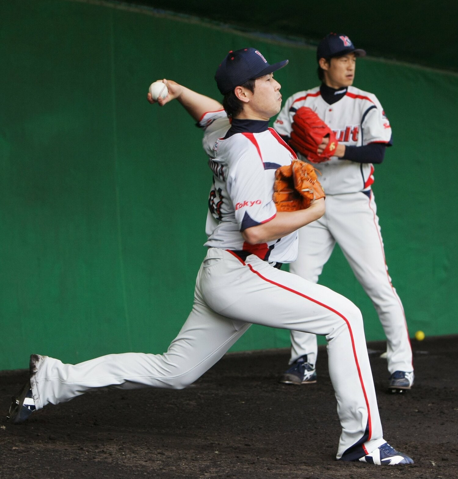 ヤクルトのブルペンで投げ込む正田(2012年)。中継ぎ陣を支えた山本哲哉(奥)は今季、共に投手コーチとしてタッグを組んでいる ©JIJI PRESS