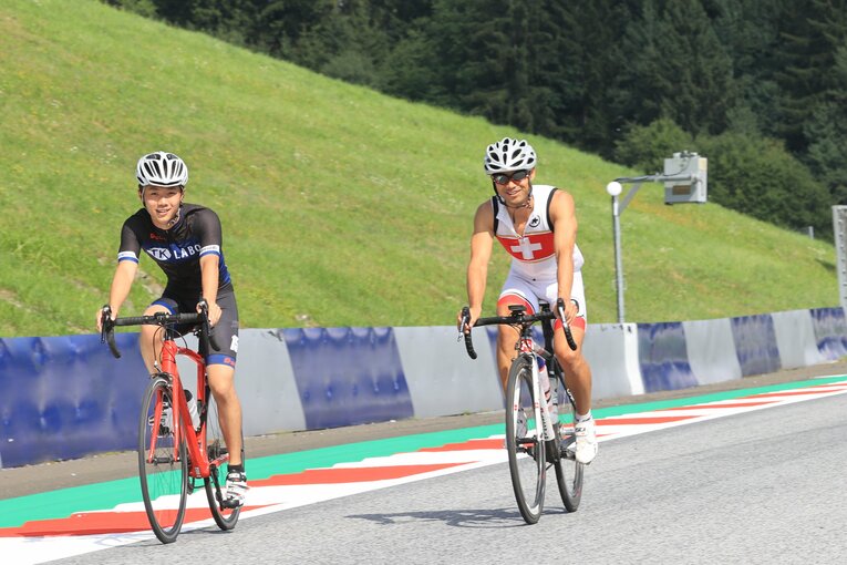 レッドブルリンクで自転車トレーニングに励む古里。元GPライダーの青山博一監督（右）と比べると、16歳ならではの身体の線の細さが際立つ